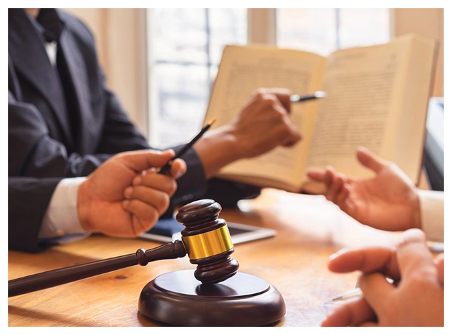 A group of people sitting around a table with papers and a gavel.