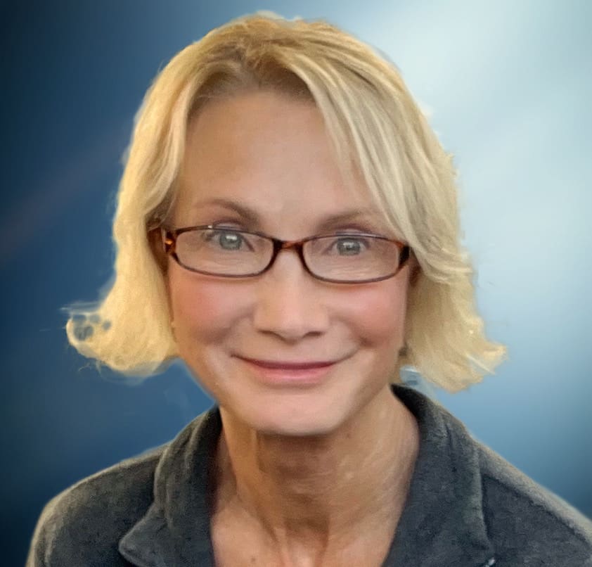 Smiling woman with blonde hair and glasses.