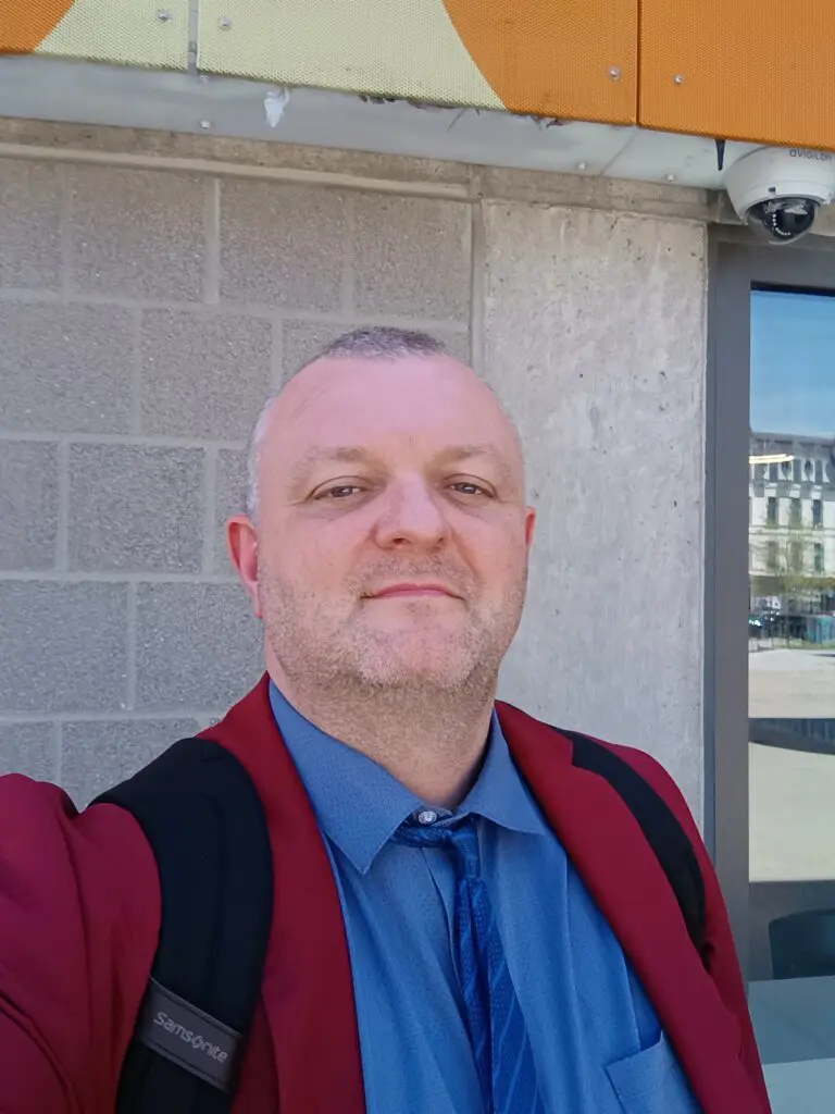 Man in red blazer and blue shirt.