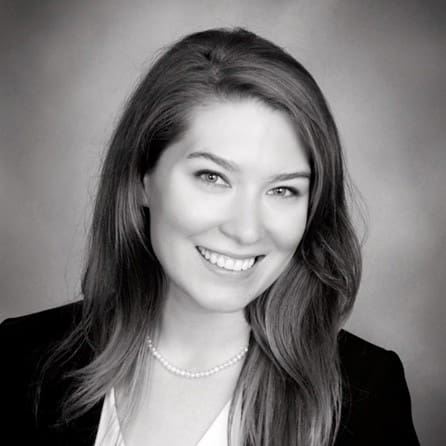 Black and white headshot of a smiling woman.