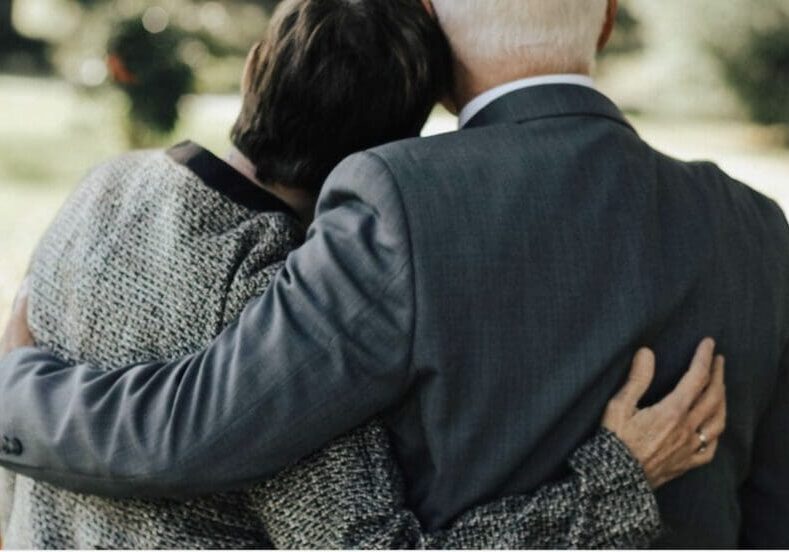 A man and woman hugging each other.